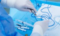 Surgeon with syringe Surgeon in scrubs and proective gloves with syringe