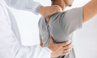 Physiotherapist doing healing treatment on man’s back.Back pain patient, treatment, medical doctor, massage therapist.office syndrome Physiotherapist doing healing treatment on man's back.Back pain patient, treatment, medical doctor, massage therapist.office syndrome